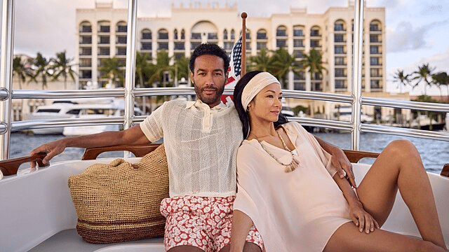 Couple on the back of a boat relaxing.